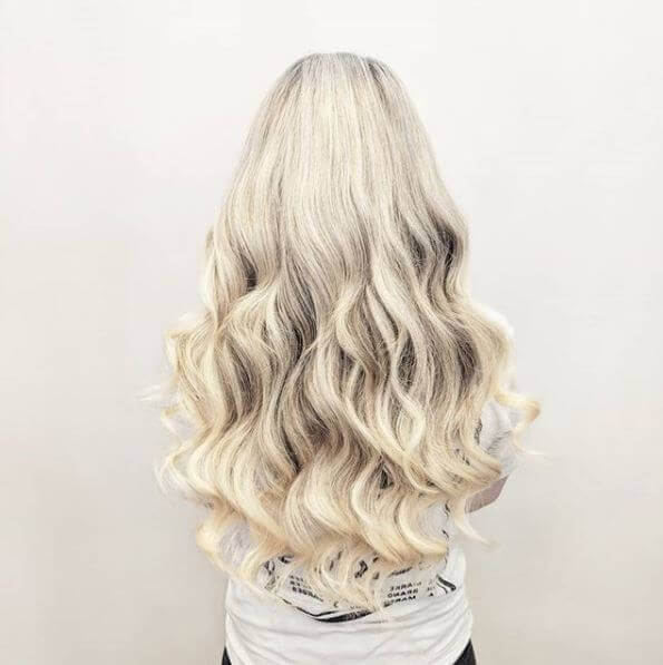 long blond wave hair extensions on client